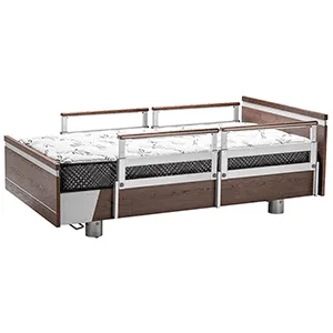 Essence 36 hospital-style bed with a wooden frame, metal side rails, and a patterned mattress, elevated on sturdy cylindrical legs.