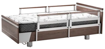 Hospital bed featuring PR39 side rails, a sturdy wood and metal frame, and a mattress with a patterned cover.