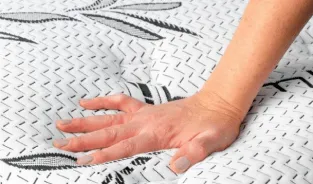A hand pressing on a SonderCare mattress