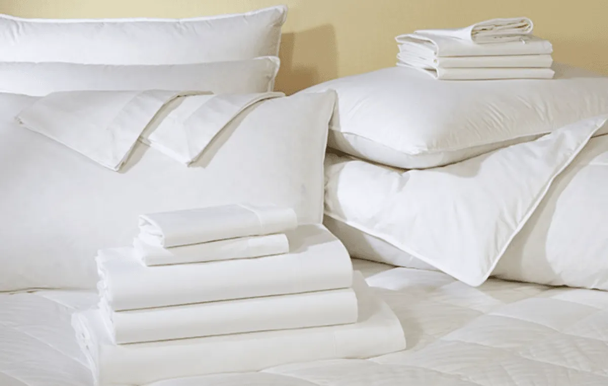 Neatly folded white SonderCare bedding and pillows