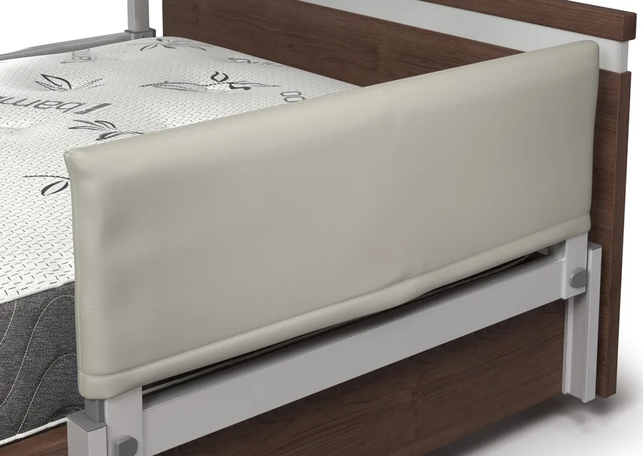 Bed with a wooden frame, white mattress, and a padded beige side rail.
