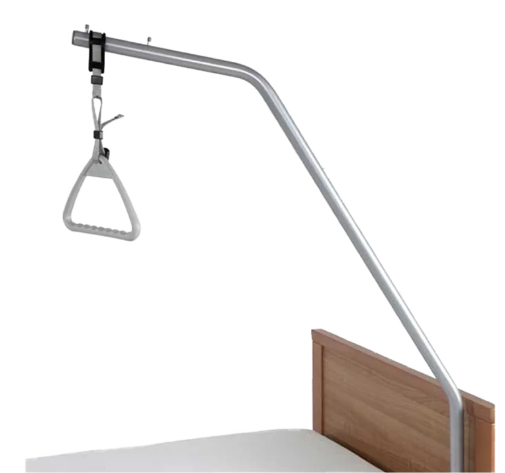 Hospital bed trapeze with a triangular handle attached to a metal frame, positioned over a bed with a wooden headboard.