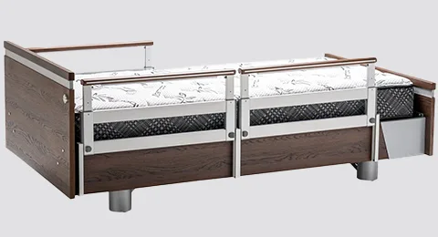 A hospital bed with side rails and a patterned mattress.