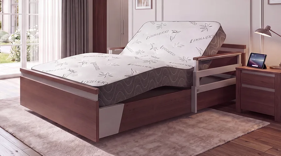 A modern Sondercare adjustable bed, featuring a Premium 39 partially elevated mattress, is placed in a bright bedroom with wooden furniture and a nightstand holding a lamp and a tablet.